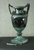 A large late 19th century majolica vase, in hues of black and green, with a pair of double