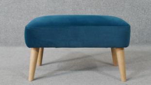 A contemporary footstool, upholstered in blue velour, on cylindrical tapering ash legs. H.33 W.56