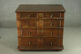 A late 17th century oak chest, with four long graduated drawers, each with brass escutcheons and