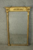 A Regency gilt framed pier mirror, the frieze with a foliate design in relief, flanked by two