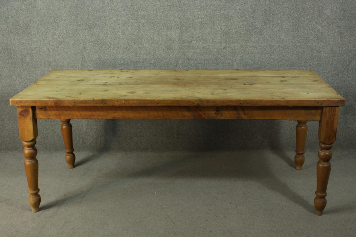 A pine refectory farmhouse dining table, with a rectangular top, on turned legs.