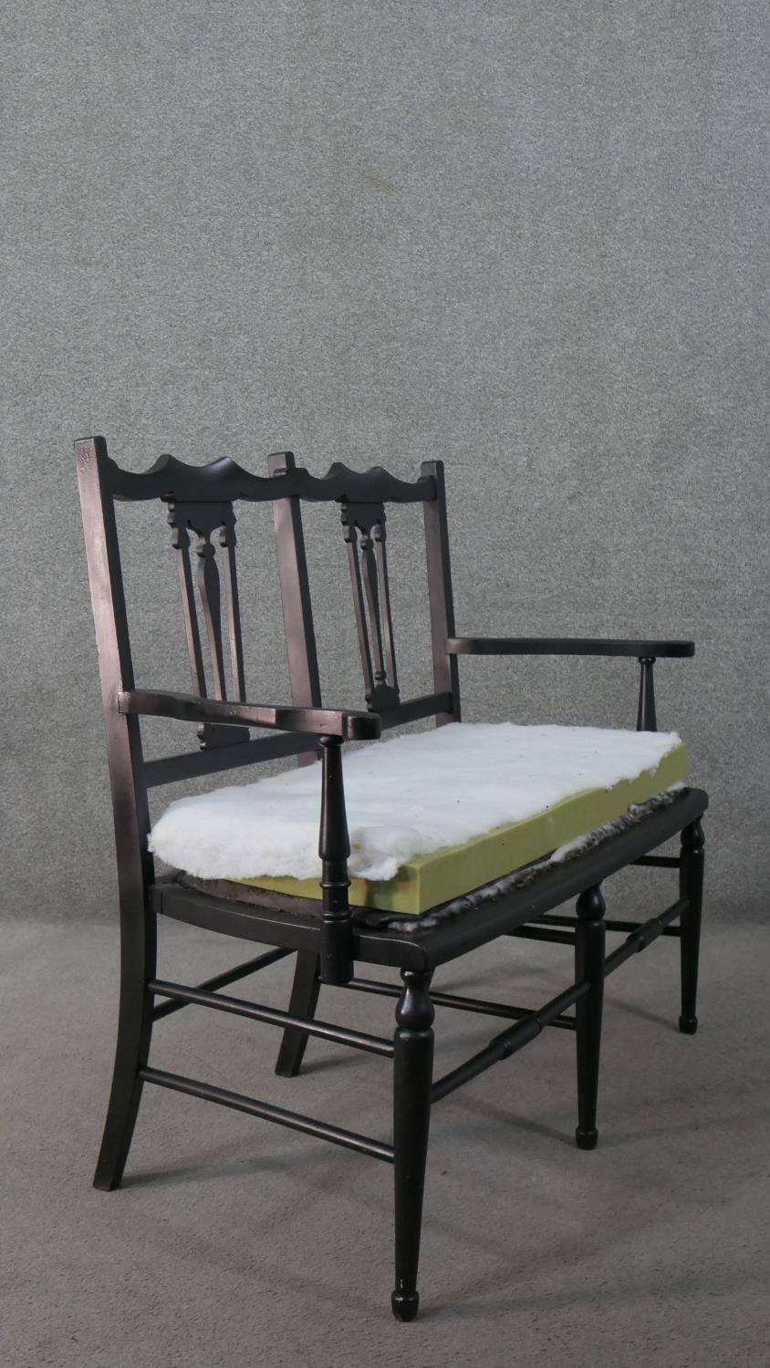 An ebonised wood two seater settee, the double chair back with pierced splats and open arms. H.90 - Image 5 of 5