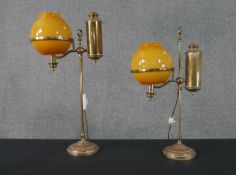 A pair of 19th century adjustable brass student's lamps with globular amber glass shades,