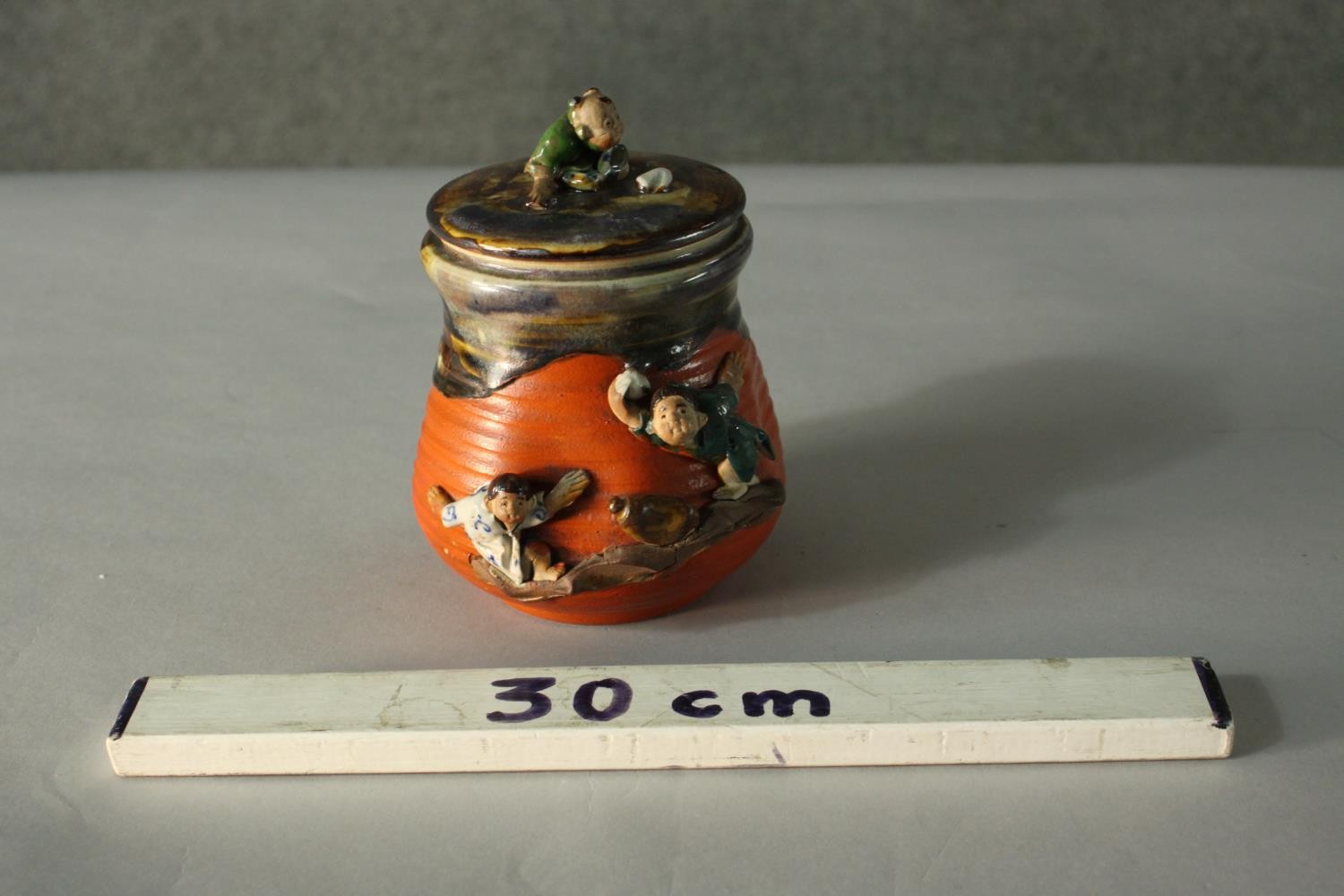 A glazed and hand painted ceramic figural design Japanese lidded jar. Decorated with young - Image 2 of 7