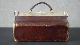 A vintage leather Gladstone bag with brass fittings. H.25 W.36 D.17cm