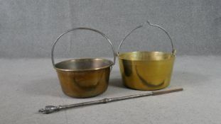 Two 19th century swing handled brass preserve pans and a Regency steel poker. H.38 W.36cm (largest)