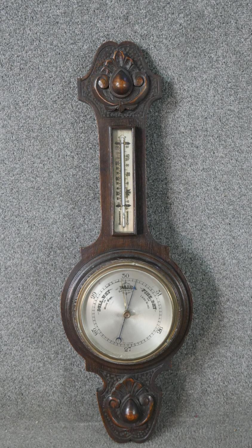 A late 19th century carved oak cased barometer with silvered dial. H.72 W.24cm