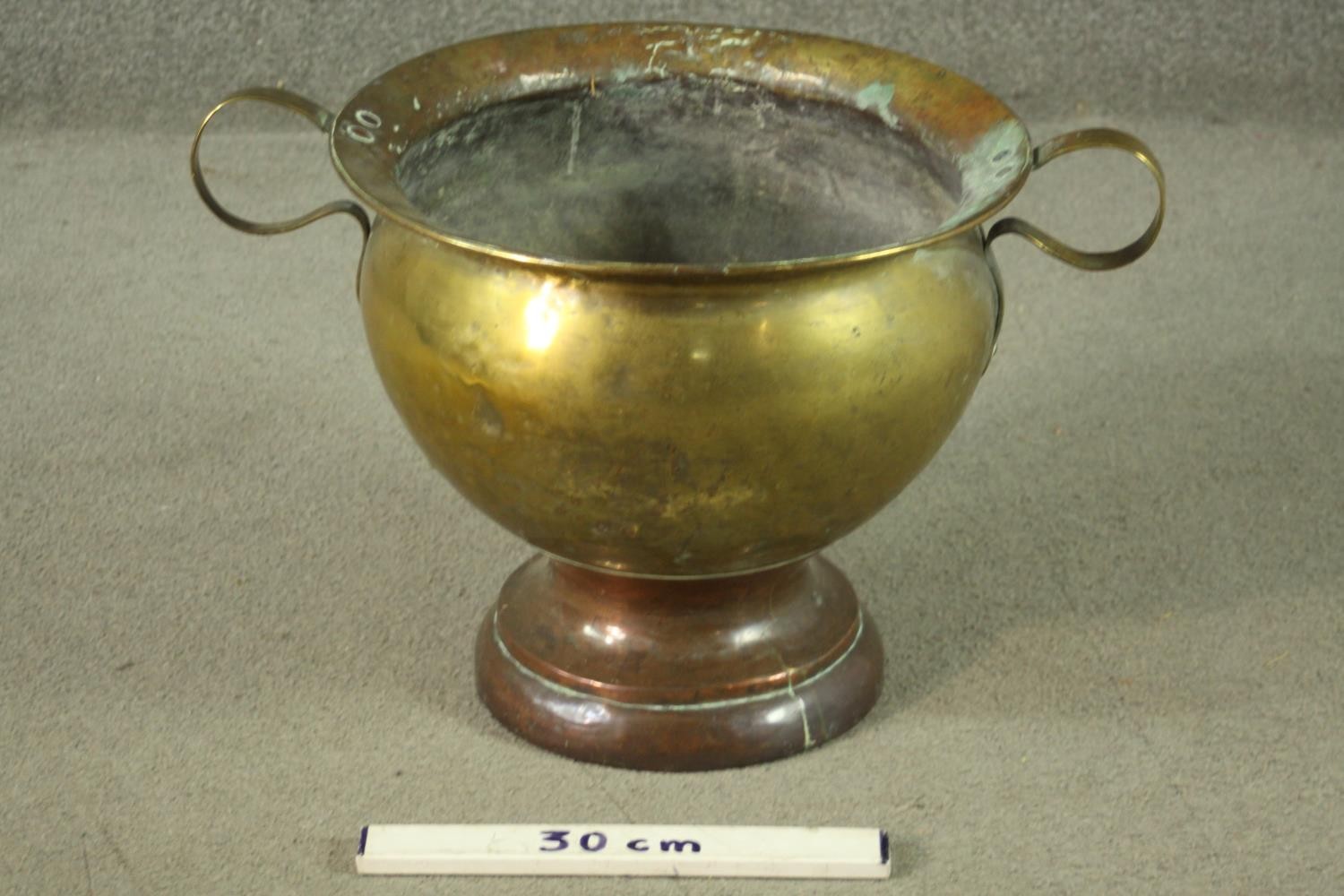 A 19th century twin handled brass pot on a copper circular stepped base. H.35 Dia.58cm. - Image 2 of 7