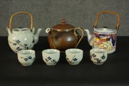 A hand painted Japanese blossom design tea pot and four tea bowls along with a matt finish treacle