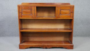 A 20th century cherrywood bookcase, with two cupboard doors centred by a shelf, over two other