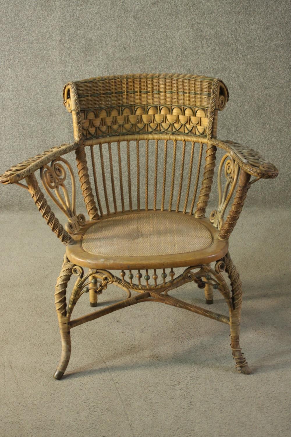A late 19th/early 20th century wicker open armchair, with a rattan woven backrest, the arms with