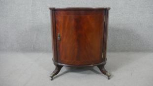 A 20th century George III style mahogany bedside cabinet, with a tooled oval green leather insert,