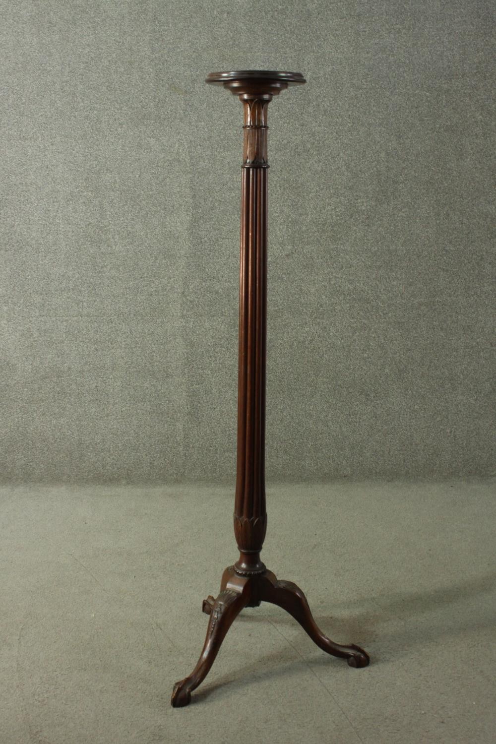 A Victorian mahogany torchere, with a circular top on a reeded stem, with a tripod base, terminating