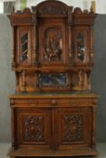 A late 19th century French provincial walnut dresser, the top section with an ornately carved panel,