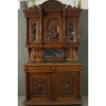A late 19th century French provincial walnut dresser, the top section with an ornately carved panel,