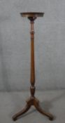 A George III style mahogany torchere, with a circular top on a reeded stem, on tripod supports. H.