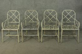 A set of four white painted cast iron garden armchairs, of faux bamboo design, with cockpen back and