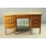 A circa 1940s oak desk, the rectangular top over two slides, and an arrangement of seven drawers