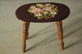 A beech stool with an oval seat, upholstered with embroidered flowers on a brown field, on turned