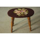 A beech stool with an oval seat, upholstered with embroidered flowers on a brown field, on turned