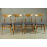 A set of four circa 1950s walnut dining chairs, with shaped backrests, over blue upholstered