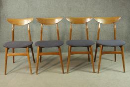 A set of four circa 1950s walnut dining chairs, with shaped backrests, over blue upholstered