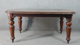 A Victorian mahogany wind-out extending dining table, the top with a moulded edge and additional