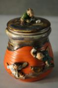 A glazed and hand painted ceramic figural design Japanese lidded jar. Decorated with young