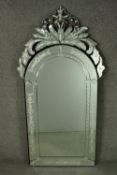 A Venetian style mirror, 20th century, of rounded arch form, with scrolling foliate cresting, the