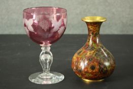 A cranberry glass etched vine design goblet along with a gilded brass Japanese cloisonné vase