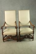 A pair of French walnut Louis XIV style fauteuil armchairs, the cream leather back and seat with