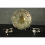 Three pieces of silver plate, including a milk jug and sugar bowl along with a repousse floral and