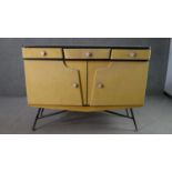 A circa 1950s sideboard, with a white formica top, covered in yellow fabric, with three short