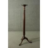 A Victorian mahogany torchere, with a circular top on a reeded stem, with a tripod base, terminating