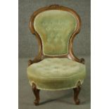 A late 19th century French walnut nursing chair, upholstered with green velour to the buttoned