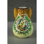 A Japanese hand painted porcelain gourd form vase decorated with a phoenix among foliage, wing