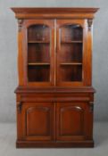 A Victorian style walnut bookcase, with a pair of glazed doors enclosing shelves, flanked by a