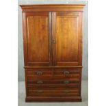 A Victorian walnut linen press, with two cupboard doors enclosing linen slides, over two short and