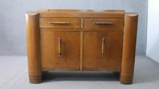 A 1930s oak sideboard, with a gallery back over two short drawers, above two cupboard doors, on