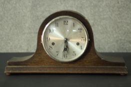 A circa 1920s oak Napoleon hat mantle clock, the silvered dial with Arabic numerals. H.23 W.42 D.