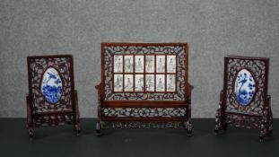 Three Chinese rosewood table screens, the largest set with twelve monochrome porcelain panels