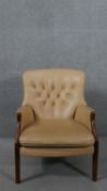 A tan leather Parker Knoll armchair, with buttoned back, on mahogany legs, with maker's label.