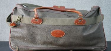 A Mulberry scotchgrain leather travelling holdall with extending pull along handle and wheels,