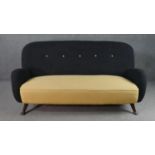 A circa 1950s two seater sofa,, the buttoned back upholstered in black fabric, over a yellow