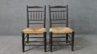 A pair of 19th century Sussex style ebonised ash side chairs, with turned spindle backs, over rush