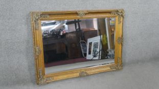 A rectangular gilt framed wall mirror, with a bevelled mirror plate, the frame with moulded