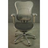 A Formway style office chair, in grey, with a pierced back, and adjustable arms, on a five point