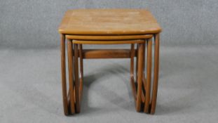 A nest of three Nathan teak tables, with crossbanded tops, on curved legs, with paper label to the