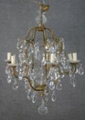 A vintage seven branch chandelier with scrolling gilt metal frame and cut crystal drops. H.80 W.60cm