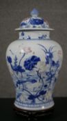 A Chinese baluster form porcelain jar and cover, blue and white, painted with flowers and storks,